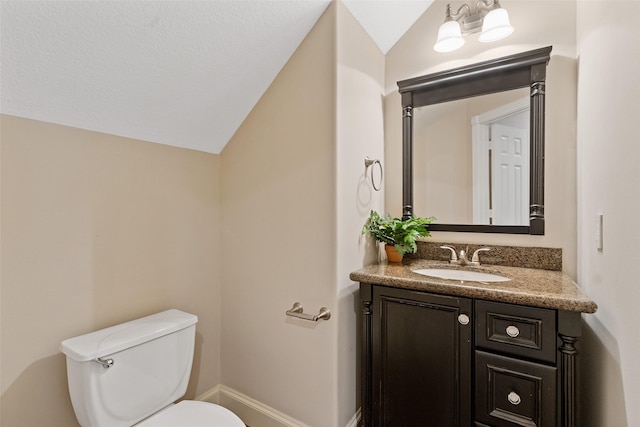 bathroom featuring vanity, toilet, and lofted ceiling