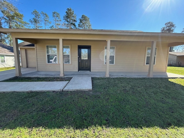 back of property featuring a porch, a yard, and a garage