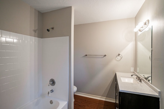 full bathroom with bathing tub / shower combination, hardwood / wood-style floors, vanity, a textured ceiling, and toilet