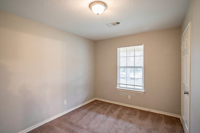 empty room featuring a textured ceiling and carpet flooring