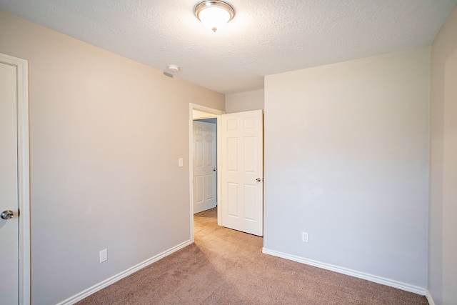 carpeted spare room with a textured ceiling