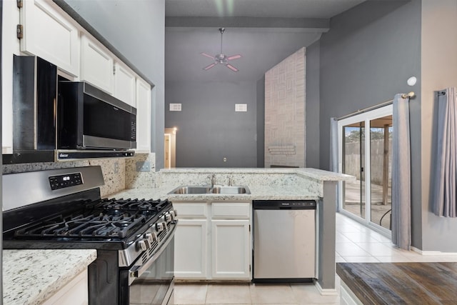 kitchen featuring sink, light stone countertops, appliances with stainless steel finishes, light tile patterned flooring, and white cabinetry