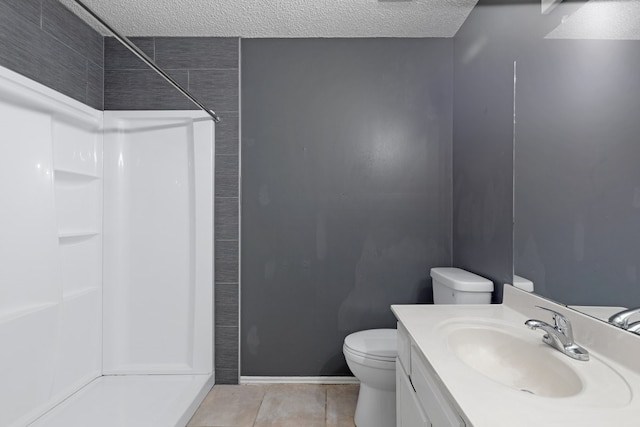 bathroom featuring toilet, vanity, a textured ceiling, and walk in shower