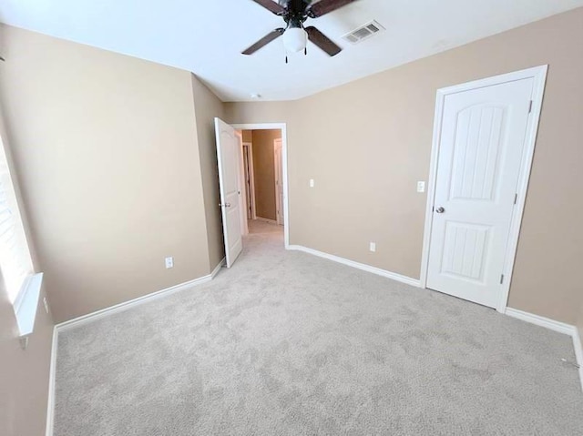 unfurnished bedroom with ceiling fan and light colored carpet