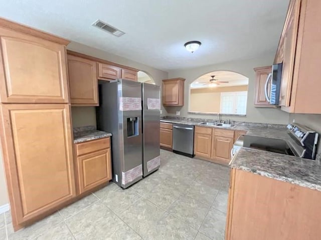 kitchen featuring ceiling fan, sink, stainless steel appliances, and stone counters