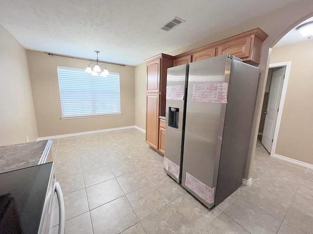 kitchen featuring range, decorative light fixtures, stainless steel refrigerator with ice dispenser, and a notable chandelier