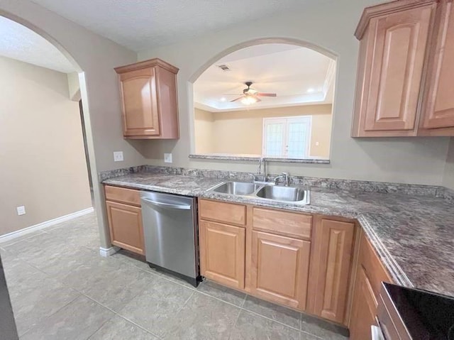 kitchen featuring ceiling fan, sink, stainless steel dishwasher, dark stone countertops, and range