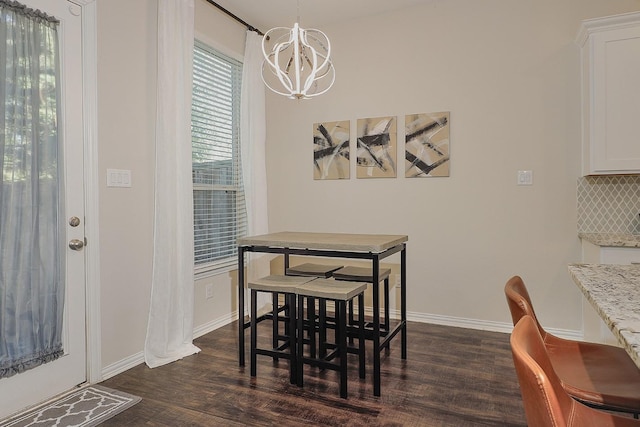 dining space featuring dark hardwood / wood-style floors and a chandelier