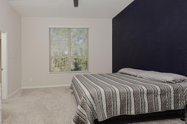 bedroom featuring multiple windows, light colored carpet, and ceiling fan