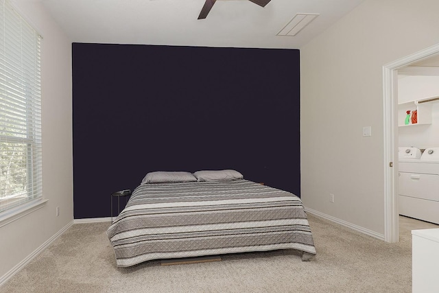 carpeted bedroom featuring independent washer and dryer and ceiling fan