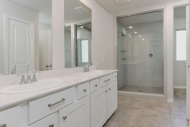 bathroom featuring tile patterned flooring, vanity, and walk in shower