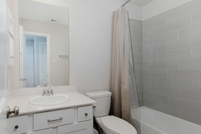 full bathroom with vanity, shower / tub combo, and toilet