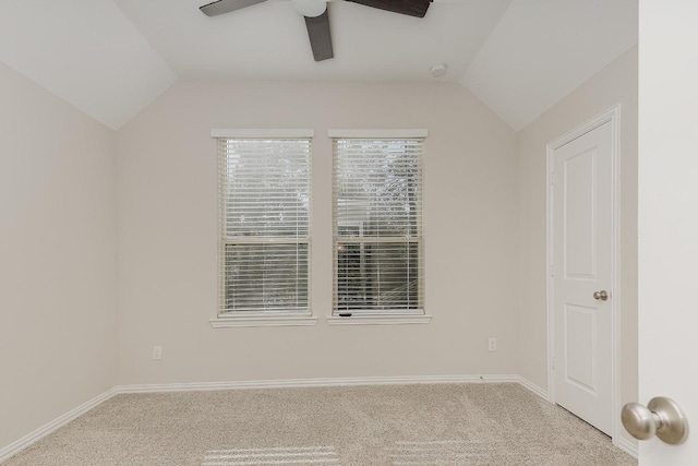 empty room featuring light carpet, vaulted ceiling, and ceiling fan