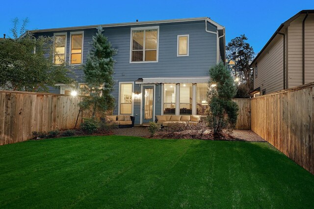 back of house featuring an outdoor living space and a yard