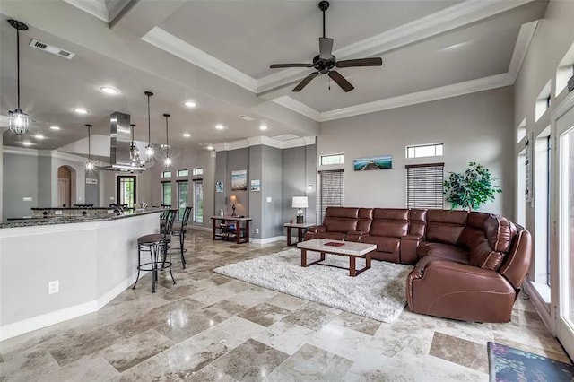 living room with ceiling fan and ornamental molding