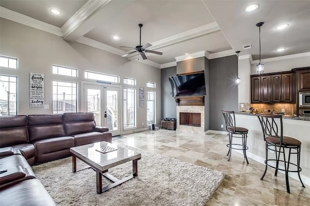 living room with beamed ceiling, ceiling fan, crown molding, and french doors