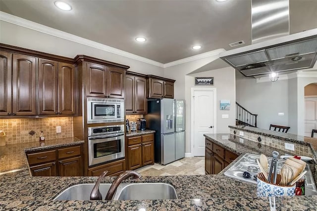 kitchen with dark stone counters, sink, tasteful backsplash, dark brown cabinetry, and stainless steel appliances