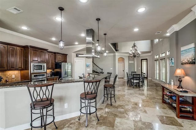 kitchen featuring dark stone countertops, a kitchen bar, island exhaust hood, and appliances with stainless steel finishes