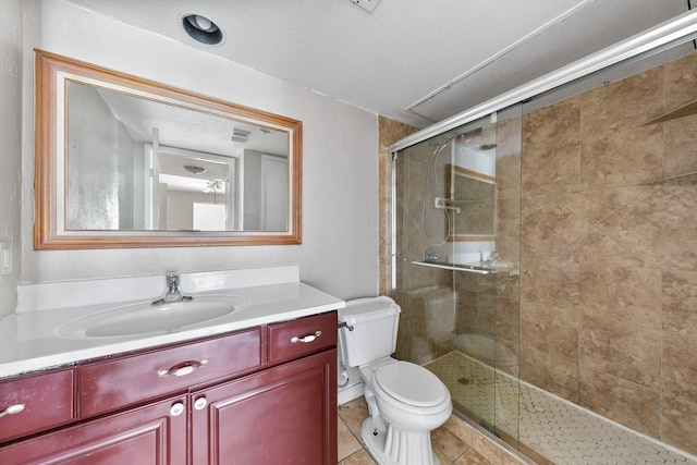 bathroom featuring tile patterned floors, vanity, toilet, and walk in shower