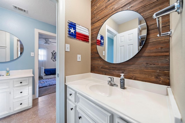 bathroom featuring vanity, ceiling fan, and wood walls