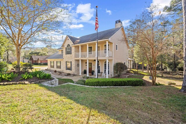 back of property featuring a yard, a balcony, and ceiling fan