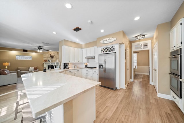 kitchen featuring white cabinetry, appliances with stainless steel finishes, sink, and a kitchen breakfast bar