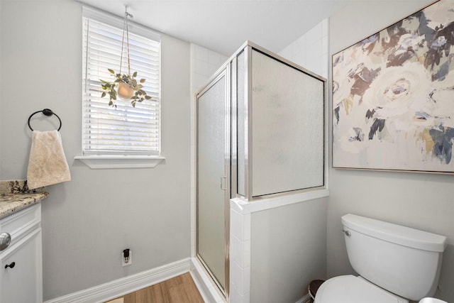 bathroom featuring toilet, wood-type flooring, vanity, and walk in shower