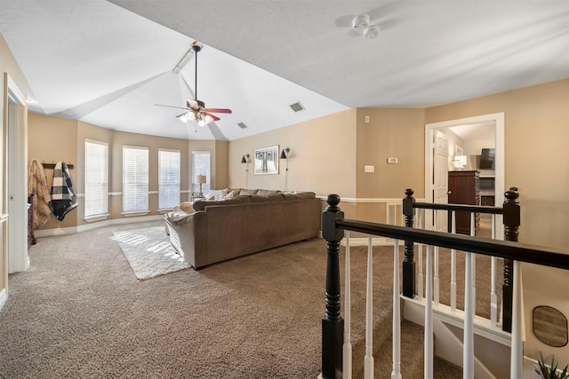 living room with ceiling fan, lofted ceiling, and carpet flooring