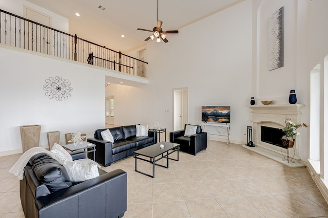 tiled living room with ceiling fan and a high ceiling