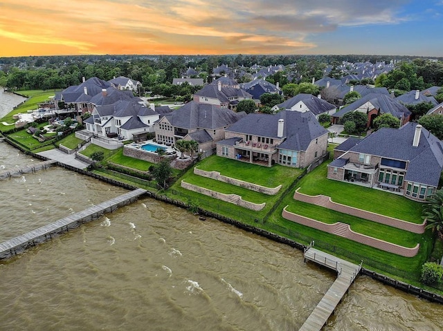 aerial view at dusk featuring a water view