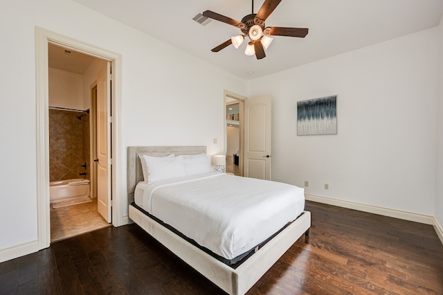 bedroom with ceiling fan, ensuite bathroom, and dark wood-type flooring