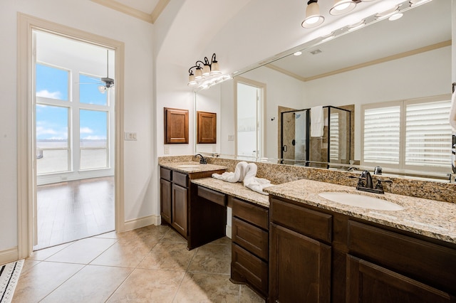 bathroom with tile patterned floors, a wealth of natural light, crown molding, and a shower with door