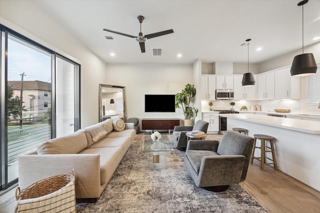 living room featuring light wood-type flooring and ceiling fan