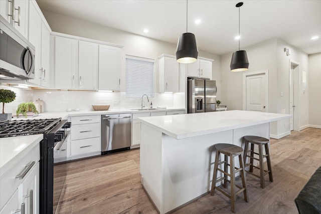 kitchen featuring white cabinets, a center island, sink, and stainless steel appliances