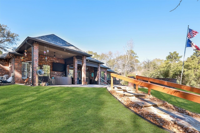 rear view of property featuring a patio, ceiling fan, and a lawn