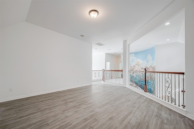 empty room featuring hardwood / wood-style flooring and lofted ceiling