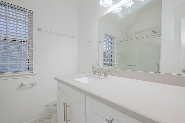 bathroom featuring a wealth of natural light, vanity, toilet, and walk in shower