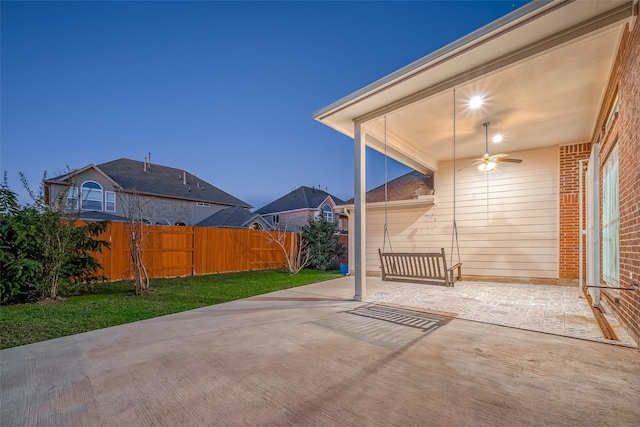 patio terrace at dusk featuring ceiling fan