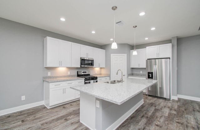 kitchen featuring white cabinets, a center island with sink, sink, and appliances with stainless steel finishes