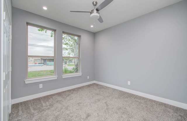 spare room featuring ceiling fan and light carpet