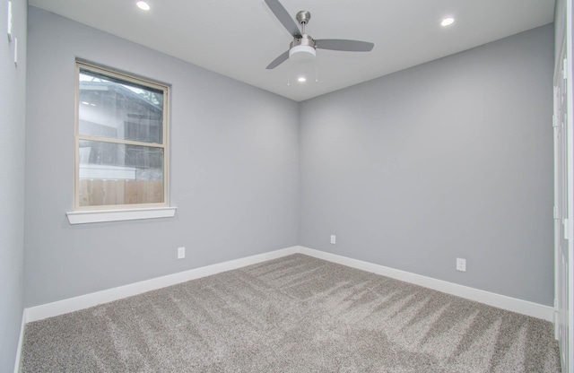 carpeted spare room featuring ceiling fan