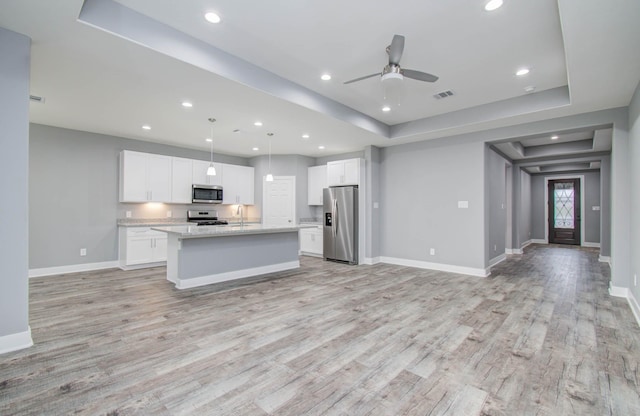 kitchen featuring white cabinetry, a center island, pendant lighting, and appliances with stainless steel finishes