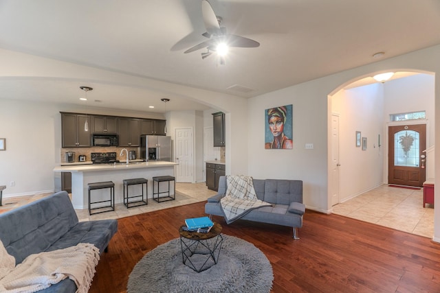 living room with ceiling fan and light hardwood / wood-style flooring