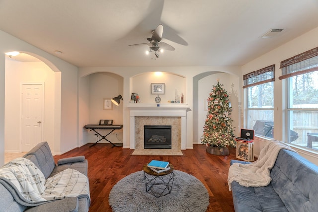 living room with a fireplace, a wealth of natural light, dark hardwood / wood-style floors, and ceiling fan