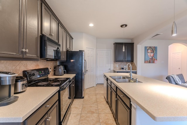 kitchen featuring backsplash, sink, an island with sink, and black appliances