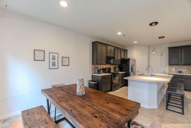 kitchen featuring decorative backsplash, sink, a kitchen island with sink, and black appliances