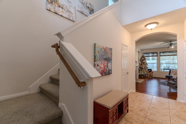 stairway with tile patterned floors and ceiling fan