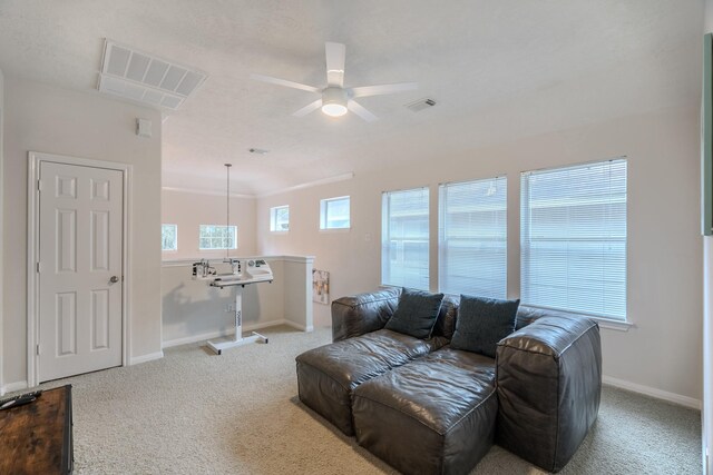 carpeted living room featuring ceiling fan and ornamental molding