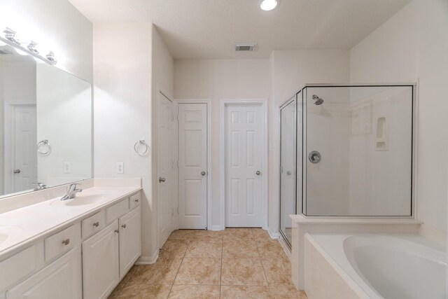 bathroom featuring tile patterned flooring, vanity, and separate shower and tub