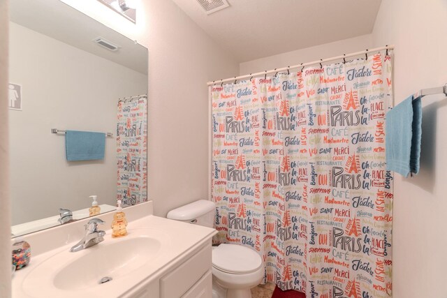 bathroom featuring vanity, toilet, and walk in shower